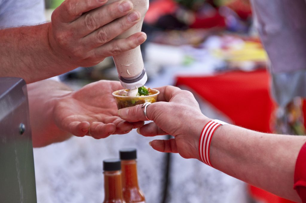 A customer gets a sample of chili along with garnishes at a chili cooking competition. Please see a related chili picture from my portfolio: