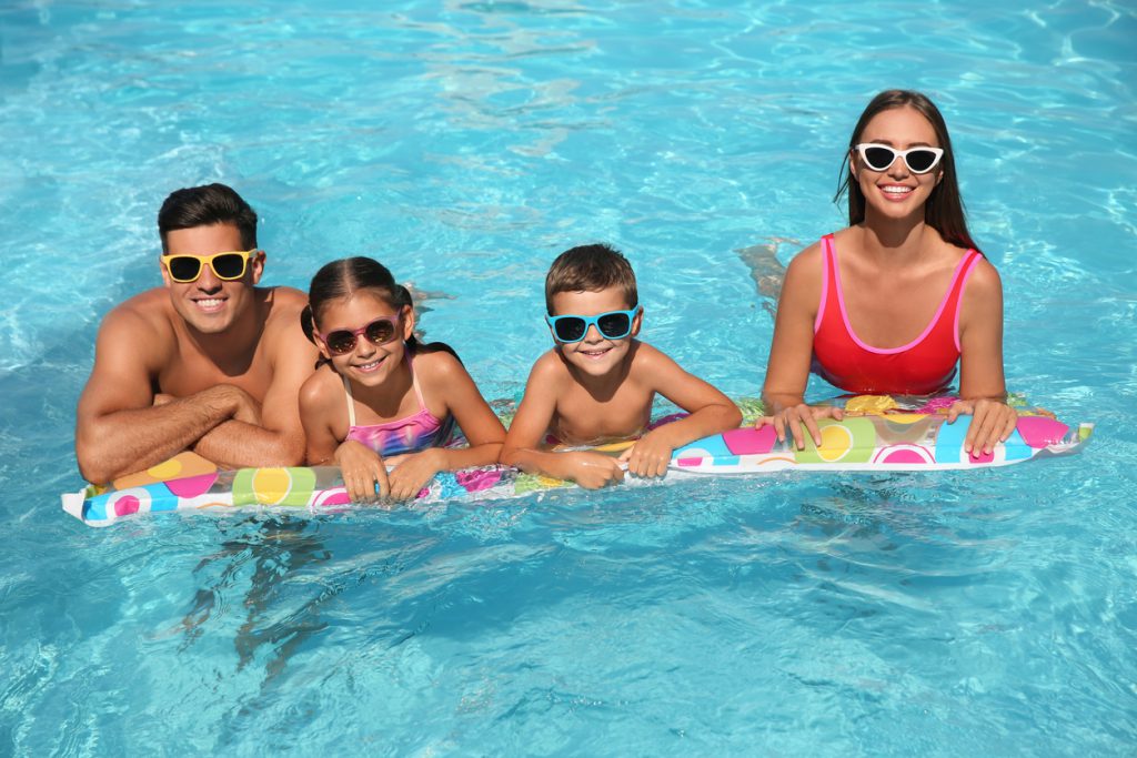 Happy family on inflatable mattress in swimming pool at Sandy Beach Oceanfront Resort